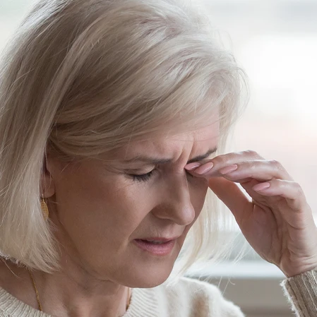 A woman rubbing her dry, itchy eyes